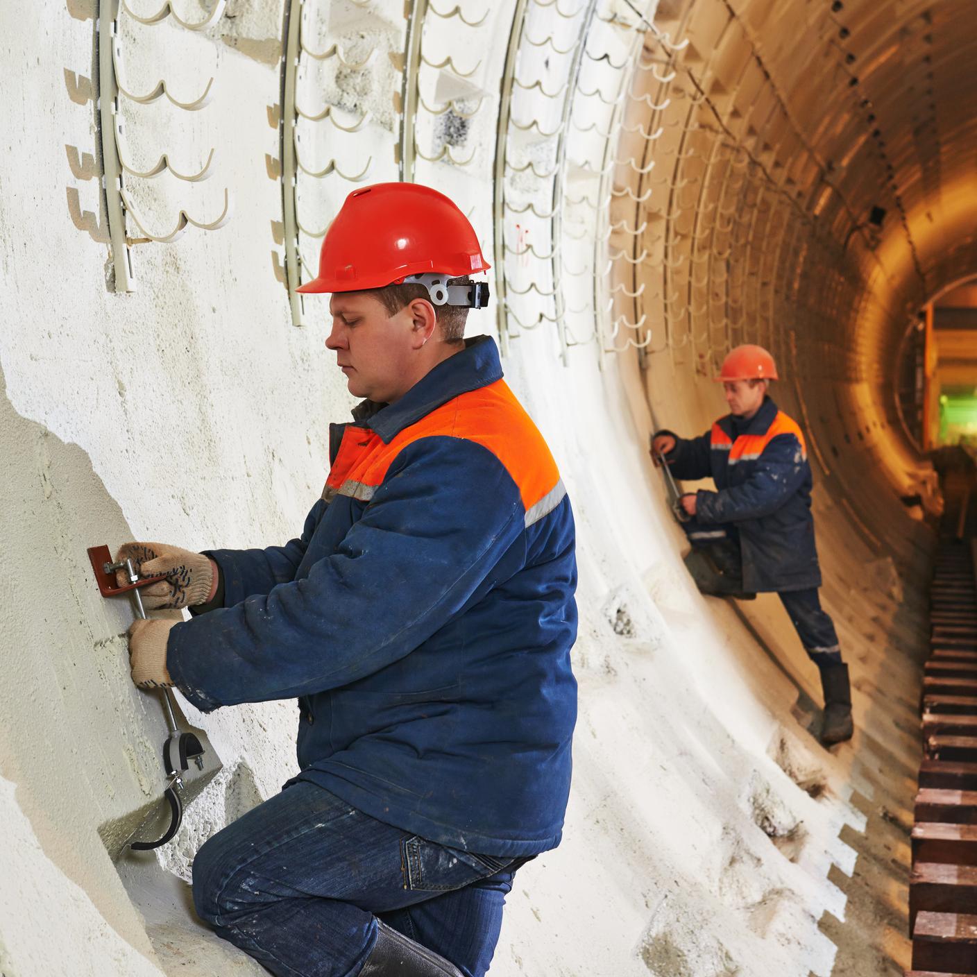 Budowniczy tunelu instalujący osprzęt na placu budowy metra