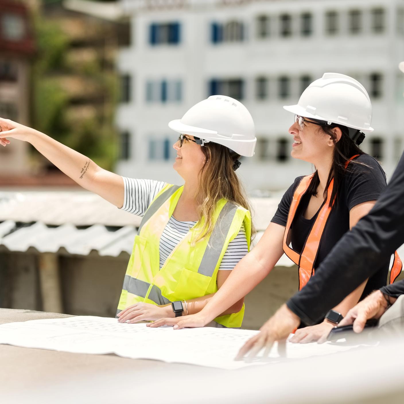 Shot of construction workers and architect reviewing blueprint at construction site
