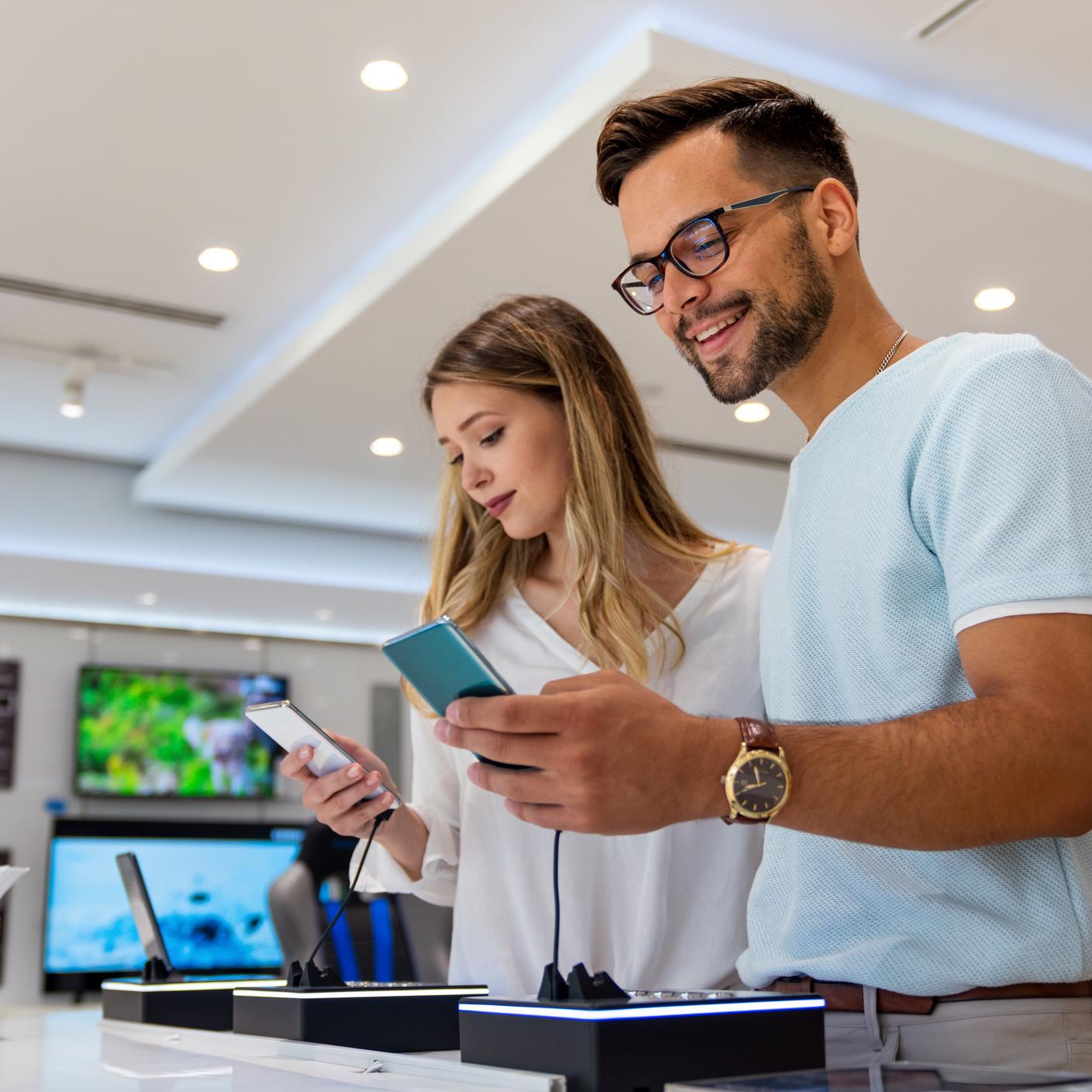 Kitemark - Happy young people buying a new smartphone in mobile shop