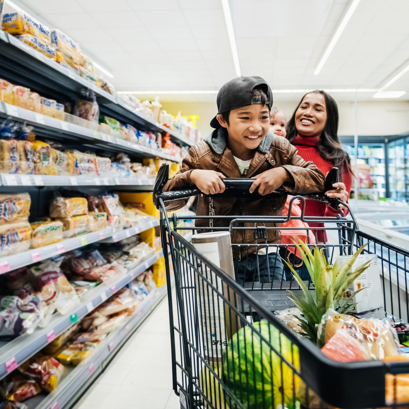 mom and kid in trolley at supermarket