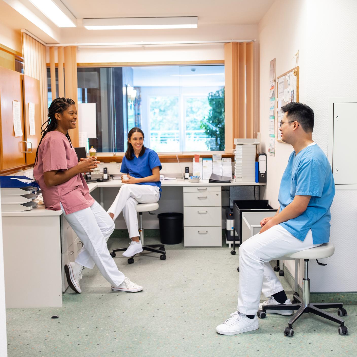 Hospital staff having coffee and talking during break. Male and female healthcare workers having a casual talk during a break in hospital.