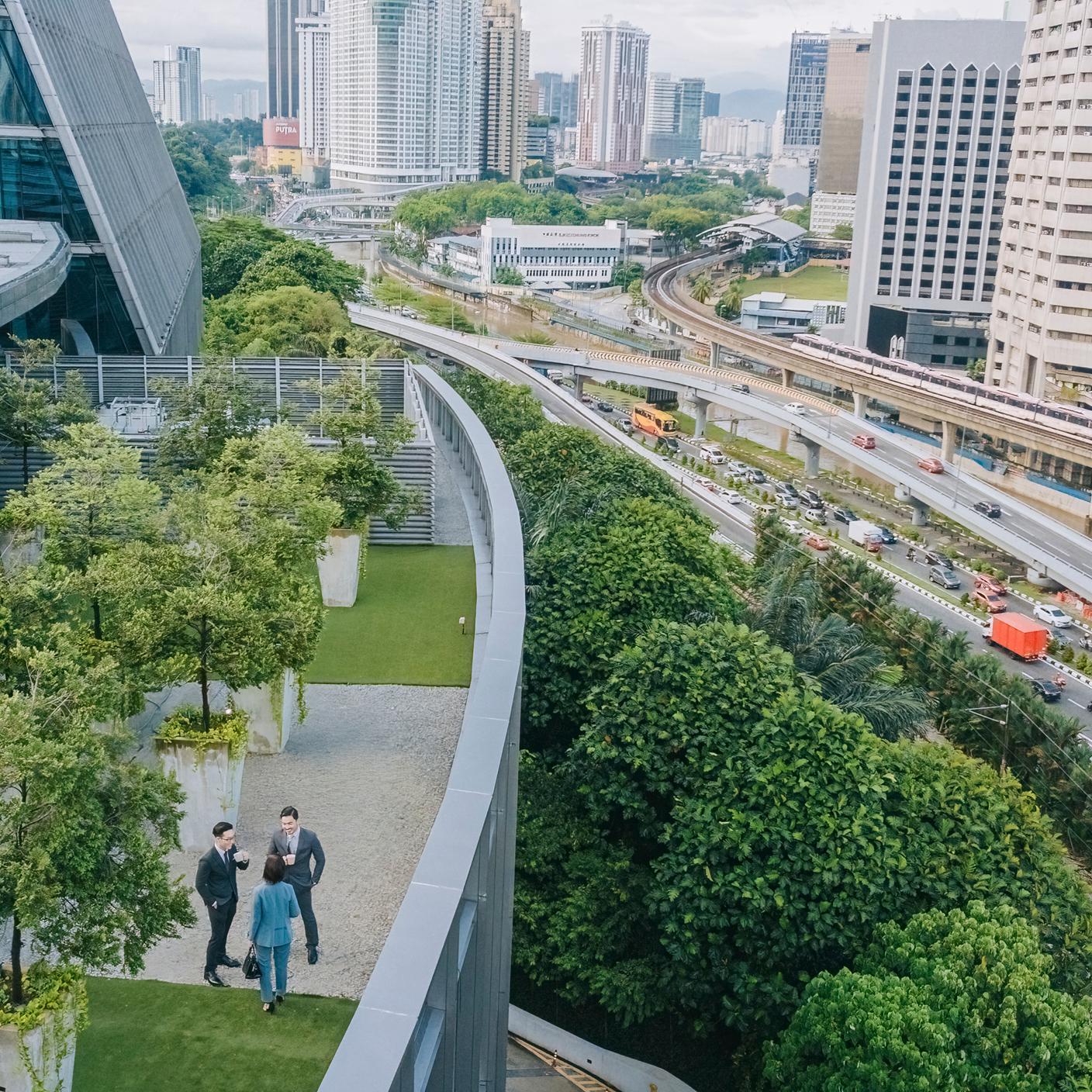 directly above 3 business person talking on roof top garden outside office building