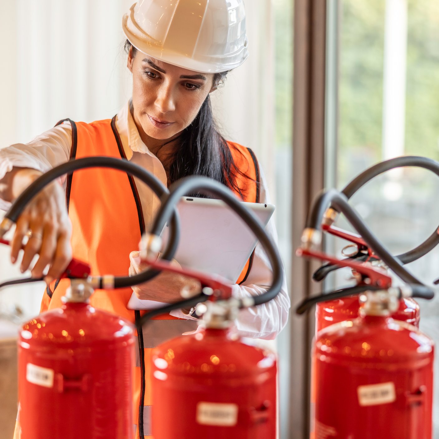 A female safety inspector checks the fire extinguishers in the hotel restaurant.