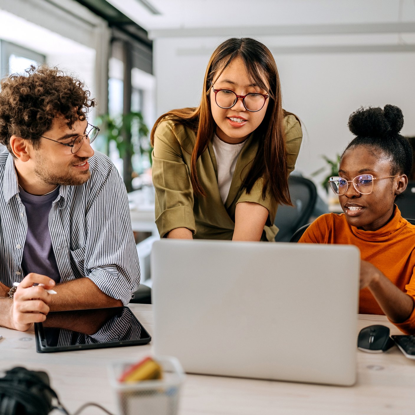 Three young colleagues discussing work at modern office