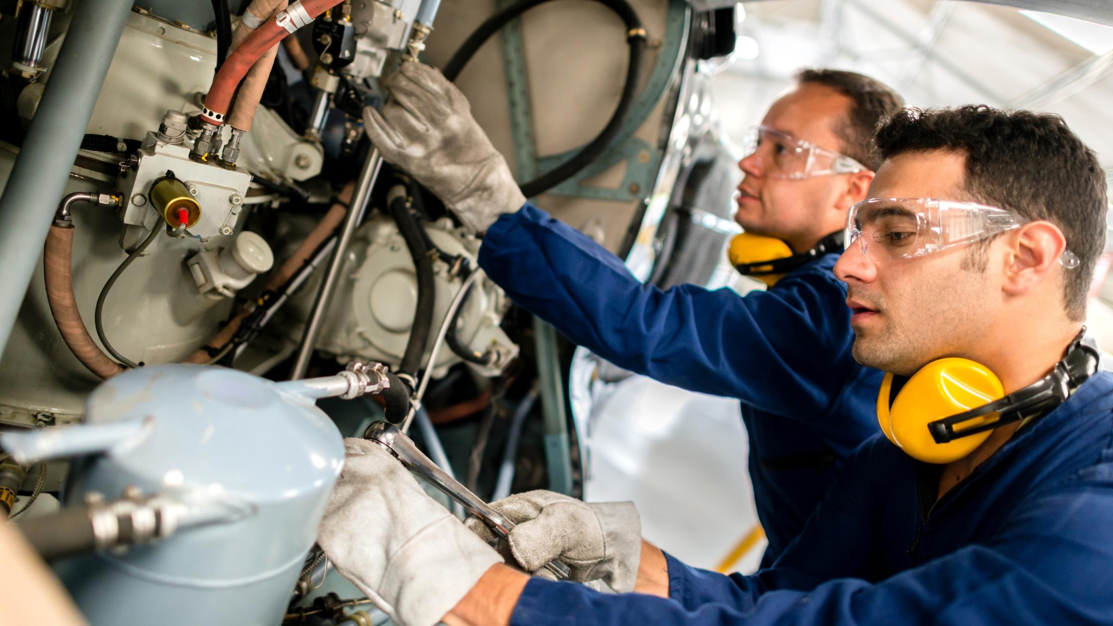 Two engineers working on an engine