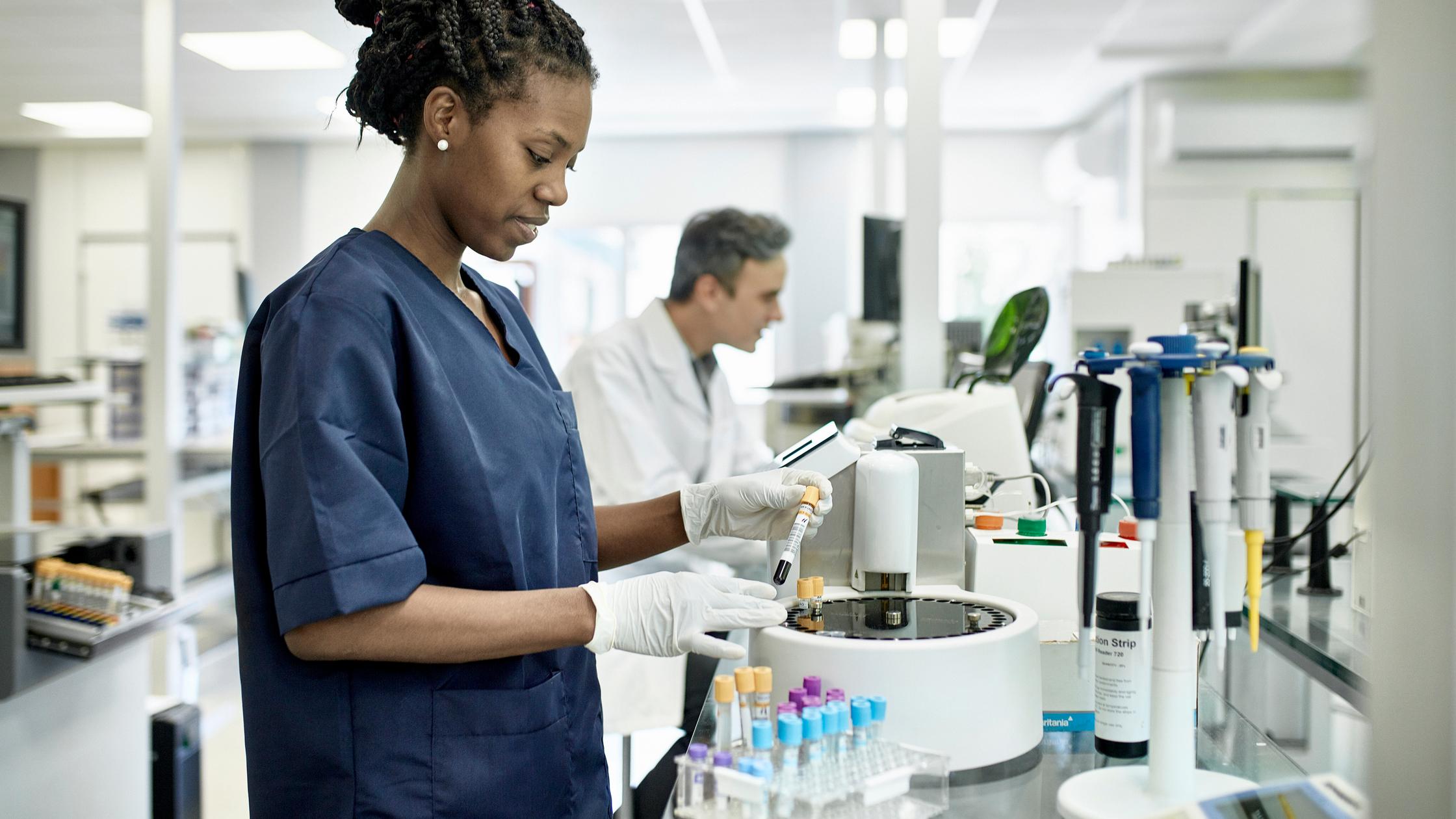 Técnico en patología con uniforme azul en prueba de laboratorio
