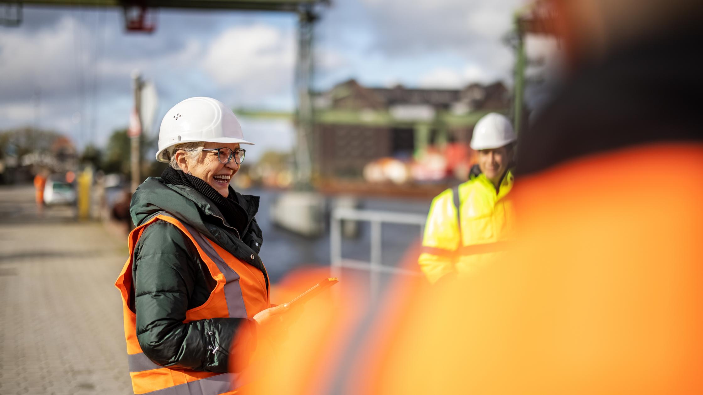 Senior Managerin lacht mit Team an großem Ladedock
