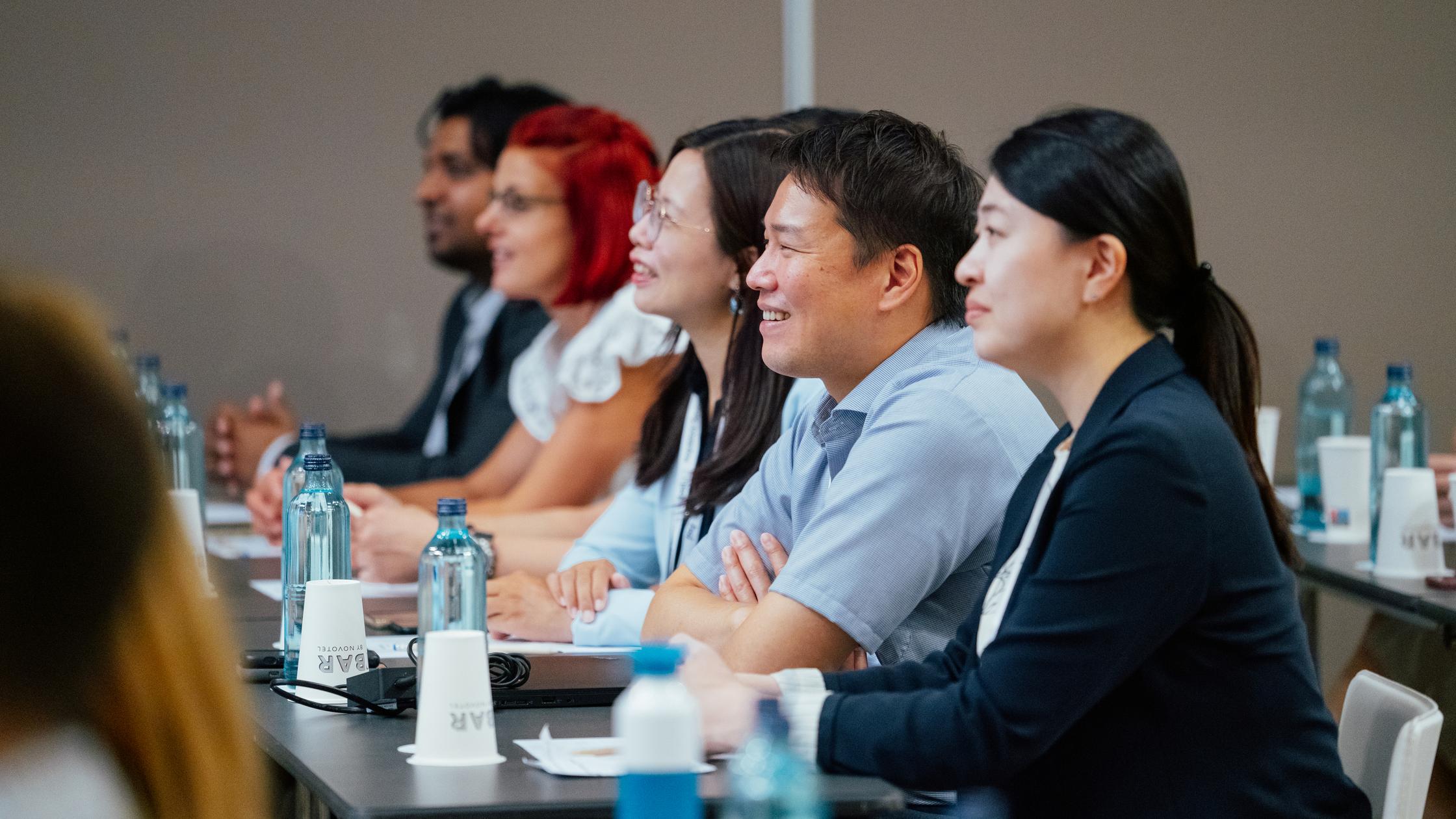 People smiling and listening in a meeting